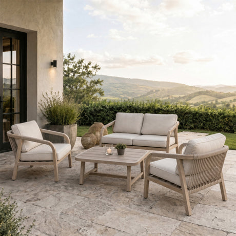 Hill Interiors Outdoor Four Seater Garden Lounge Set in brown with two armchairs, loveseat and coffee table on a stone patio overlooking rolling hills.
