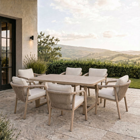 Hill Interiors Outdoor 6 Seater Metal Dining Set in brown with rectangular slatted table and rope-detail chairs with cream cushions on a countryside patio.