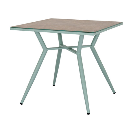 Hill Interiors French Grey square side table with tempered glass top over a beige surface and slender pale green metal legs on a white background.