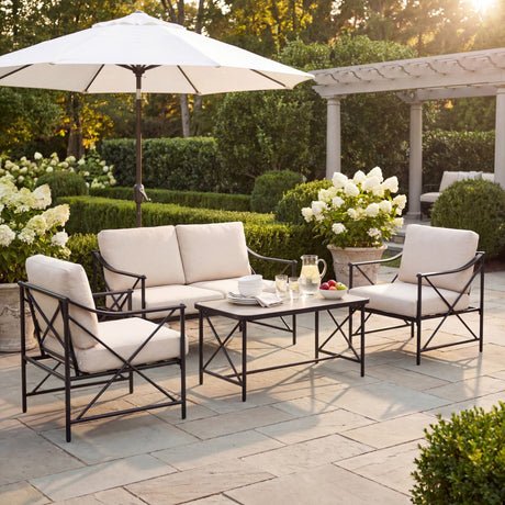 Hill Interiors Metal Four-Seater Garden Lounge Set in black with cream cushions, loveseat, two armchairs and rectangular coffee table on a garden patio.