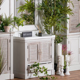 Hill Interiors Medium Stone Pillar Candle Holder in beige, shown with two shorter stone holders and pillar candles in a plant-filled living room setting.