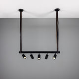 Holmes Brass 5 Light Spotlight Bar in matt black, with five cylindrical spotlights on a horizontal bar suspended by two leather straps from ceiling mounts, against a plain grey background.