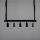 Holmes Brass 5 Light Spotlight Bar in matt black, a horizontal ceiling bar with five cylindrical spot heads, suspended by two leather straps against a plain grey background.