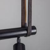 Close-up of the Holmes Brass 5 Light Spotlight Bar in matt black, showing a cylindrical spot head mounted on the horizontal bar with leather hanging straps and brass detailing.