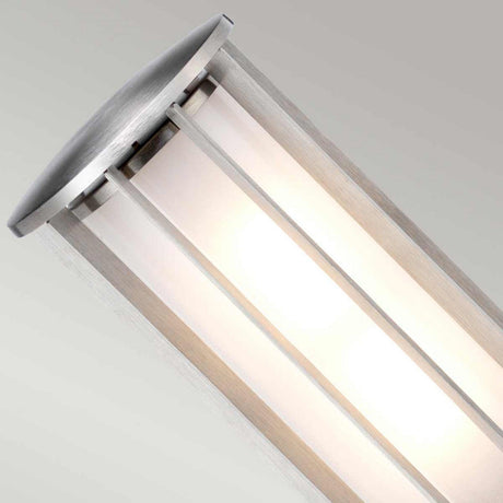 The Hornsea 1 Light Bollard in Brown features a contemporary design with a sleek stainless steel frame and frosted glass panels, emitting a warm glow. Its minimalist cylindrical shape seamlessly enhances any space, mounting elegantly against neutral backgrounds.