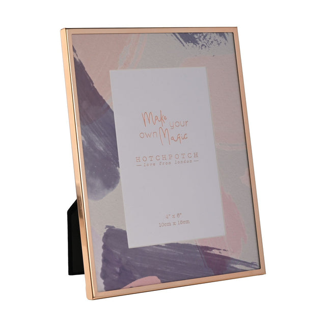 Rectangular metal photo frame with a slim rose-gold edge and pastel pink, lilac and grey brushstroke mount, holding a 6 x 4in sample print, shown on a white background.