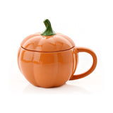 Pumpkin-shaped stoneware mug with lid, 440ml, in glossy orange with ribbed sides and a curling green stem handle on the lid, shown on a white background.