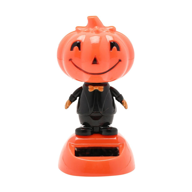 Smiling pumpkin solar bobble head ornament with a glossy orange jack-o'-lantern face, black suit, orange bow tie, and solar panel on a rounded orange base, set against a plain white background.