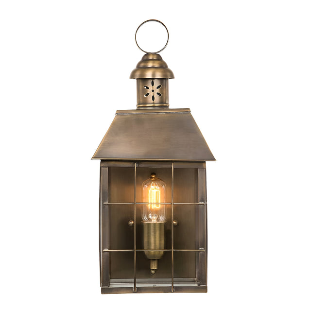 The Hyde 1 Light Outdoor Wall Light in Aged Brass offers a vintage touch with its glass cover and grid pattern. It emits a warm glow when illuminated and includes a loop on top for hanging, bringing timeless charm to any setting.
