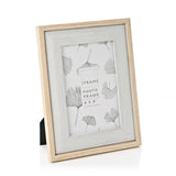 Two tone wood photo frame for a 4 x 6" picture, with light brown outer edge and grey woodgrain inner border, stood at an angle on a white background.