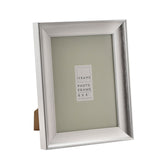 Traditional rectangular easel photo frame in brushed silver finish with sloped moulding and back stand, 6 x 8in size, shown on a plain white background.