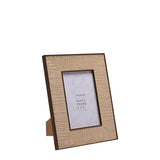 Rattan effect 4x6" photo frame in natural woven texture with dark brown edging and diagonal corner joins, shown at an angle with its back stand on a white background.