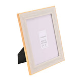 Rectangular 6x8" photo frame with a textured white face and thin gold-effect edge, shown at an angle with fold-out stand, on a plain white background.