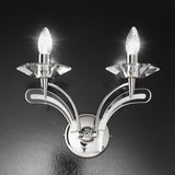 Icaro 2 Light Glass Wall Light in chrome finish with two upward-curved arms, crystal-effect glass drip pans and lit candle-style bulbs, shown against a dark background.
