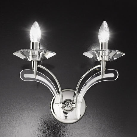 Icaro 2 Light Glass Wall Light in chrome finish with two upward-curved arms, crystal-effect glass drip pans and lit candle-style bulbs, shown against a dark background.
