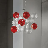 Atom 3 Light Globe Glass Chandelier in chrome, featuring clustered clear and red glass bubbles on a central rod, shown suspended against a grey wall.