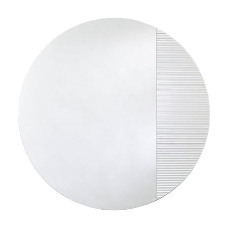 Round frameless mirror, one part plain and one part vertically fluted so the reflection breaks into bands, on a plain background.