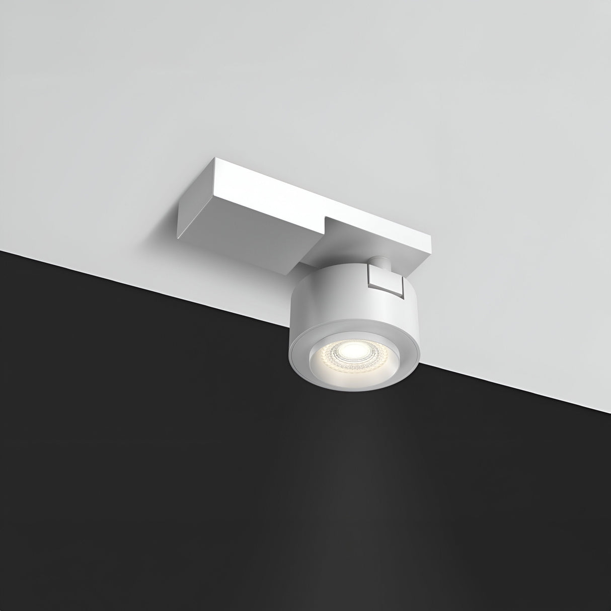 The Treo LED Single Spotlight 13W 3000K features a modern white design with a cylindrical light and square base, mounted on a contrasting black and white ceiling. Emitting a focused 36° beam, it provides energy-efficient, warm lighting for the room.