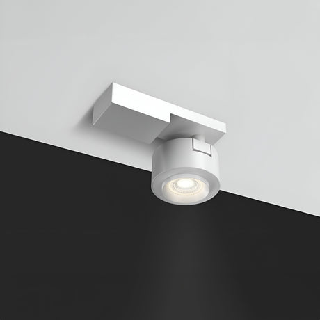 The Treo LED Single Spotlight 13W 3000K features a modern white design with a cylindrical light and square base, mounted on a contrasting black and white ceiling. Emitting a focused 36° beam, it provides energy-efficient, warm lighting for the room.