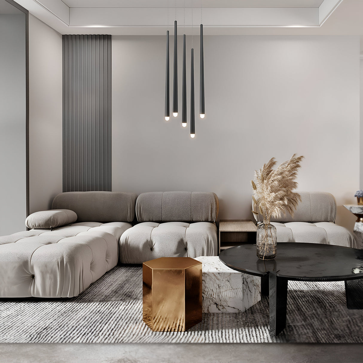 A modern beige sectional sofa, black circular coffee table, and geometric gold marble side table enhance the stylish living room. The Cascade CCT Dimmable LED Cluster Pendant Light in black illuminates the space, while pampas grass adds natural elegance to the minimalist decor and neutral tones.