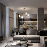 A modern living and dining room in neutral tones features a sectional sofa, marble coffee table, and the Balance 4 Light Suspension - Gold With Opal Globe. Floor-to-ceiling windows with sheer curtains illuminate the space, highlighting the sleek kitchen design and luxury lighting.