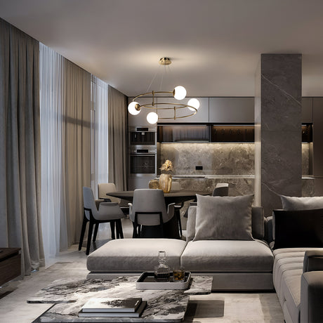 A modern living and dining room in neutral tones features a sectional sofa, marble coffee table, and the Balance 4 Light Suspension - Gold With Opal Globe. Floor-to-ceiling windows with sheer curtains illuminate the space, highlighting the sleek kitchen design and luxury lighting.