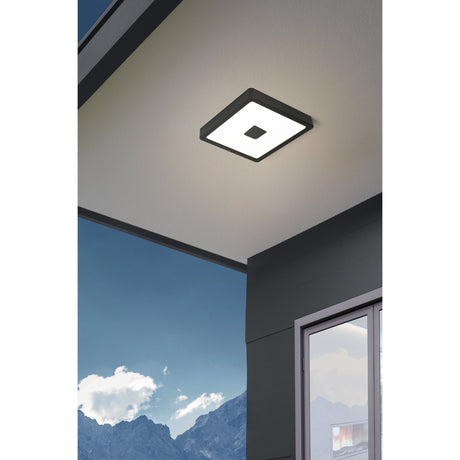 Iphias 2 LED Downlight in black, square steel frame with white diffuser and centred black square, fitted flush to a ceiling in a covered outdoor setting.