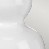 A close-up of the Isla 1 Light Table Light in glossy white with a curvy, modern design and a hint of pink, set against a light gray background.