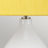 A close-up of the Isla 1 Light Table Light in white and yellow reveals its smooth, glossy ceramic base complemented by a silver-tone neck and a vibrant yellow shade, set against a plain, light gray background.