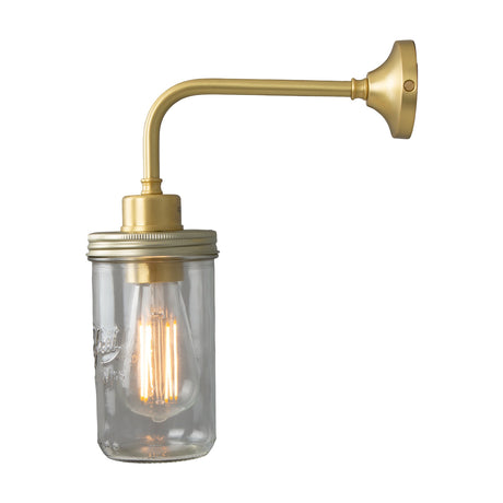 Jam Glass Wall Light with a clear glass jar shade on a swan-neck arm and round wall plate, brass and steel finish, exposed bulb, plain white background.