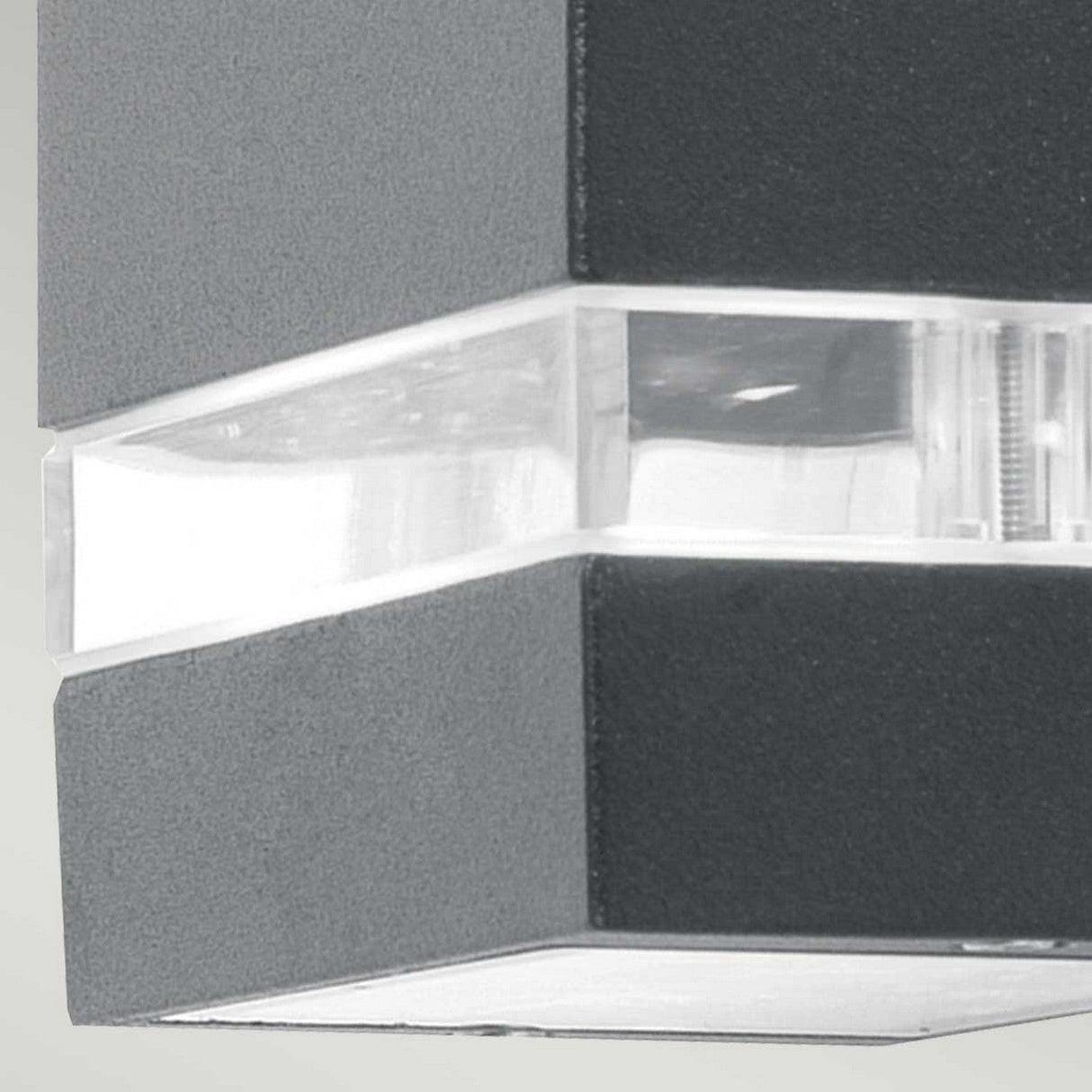 Close-up of the Jannik 1 Light Outdoor LED Wall Light, featuring a sleek graphite rectangular body and a transparent strip for illumination. Its energy-efficient lighting creates a striking effect against the light gray background, highlighting its design and durability with an IP44 rating.