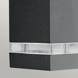 Close-up of the Jannik 2 Light Outdoor LED Wall Light - Graphite, featuring its sleek rectangular design with a graphite finish and an energy-efficient clear strip in the middle, beautifully accented against a light gray background.