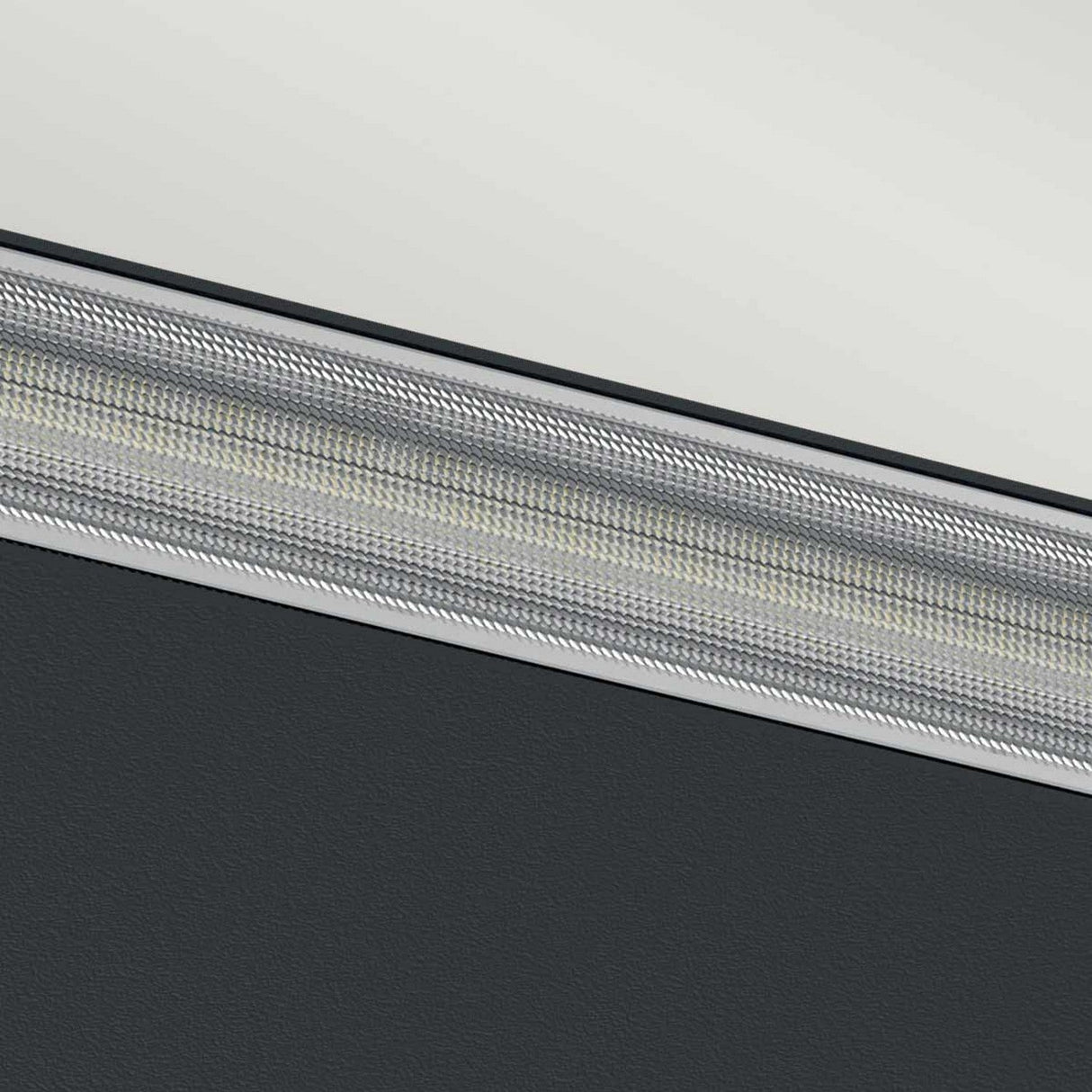Close-up of a textured, metallic surface on the Jens-1 LED Outdoor Wall Light - Black, with intricate patterns running diagonally across the image. The top section appears lighter while the bottom section is darker, creating a striking contrast between the two areas.