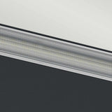 Close-up of a textured, metallic surface on the Jens-1 LED Outdoor Wall Light - Black, with intricate patterns running diagonally across the image. The top section appears lighter while the bottom section is darker, creating a striking contrast between the two areas.