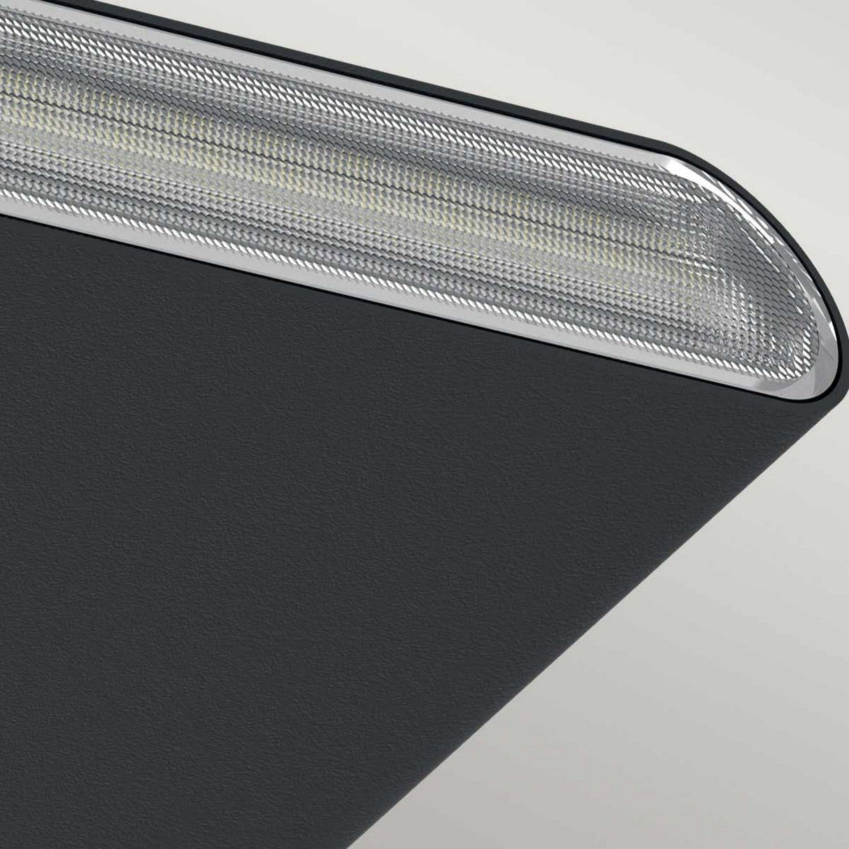 Close-up of the Jens-1 LED Outdoor Wall Light in black, featuring a modern metallic object with a smooth, dark surface and a textured silver edge. Its minimalist design is contemporary and rated IP65 for durability.