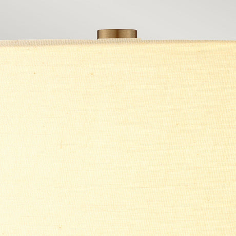 Close-up of the cream shade on the Job 1 Light Table Lamp, showcasing a brass-colored finial. The texture of the faux silk fabric is visible, with a soft gray background that enhances its elegance.