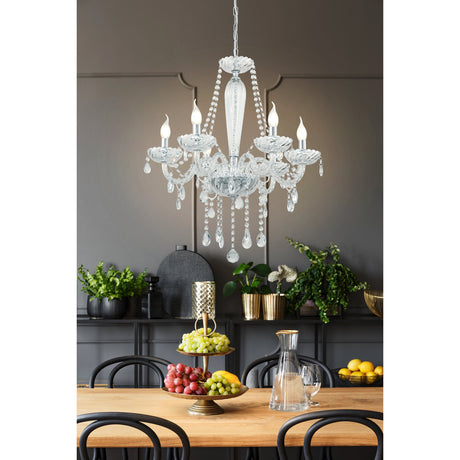 Joressa clear glass six-light chandelier-style pendant with chrome frame, candle-style arms, beaded strands and faceted drops, hung above a dining table in a grey-toned room.