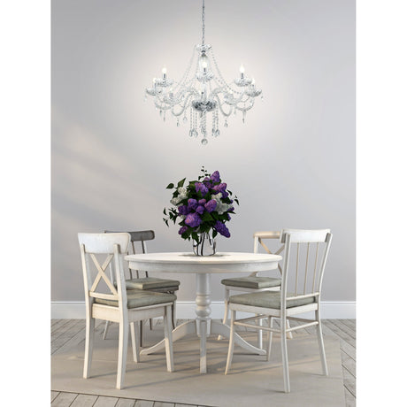 Joressa 8-light chandelier-style pendant in chrome with curving glass arms, bead swags, and faceted drops, hung above a white dining table in a light grey room.