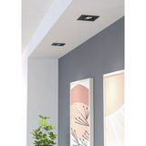Kamarne LED Downlight, square black recessed fixtures with tiltable inner ring, installed in a white hallway ceiling above a grey accent wall and framed art prints.