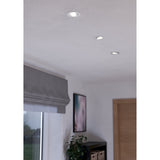 Kamarne LED Downlight set of three round white aluminium fittings with tilting silver reflector rings, recessed into a white ceiling above a window and sideboard.