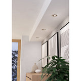 Kamarne LED Downlights, set of three round satin nickel fixtures with tiltable heads, recessed into a hallway ceiling above framed wall art and a wooden console.