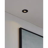 Kamarne LED Downlight, 8.8cm round black aluminium bezel with tiltable head, recessed into a white ceiling beside a wall and framed artwork in a room setting.
