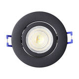 Round black aluminium LED downlight with tilting inner ring and integrated warm-white light, shown front-on with blue mounting clips on a white background.
