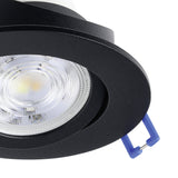 Close-up of the Kamarne black LED downlight showing the round aluminium casing, tilting inner ring with illuminated LED, and blue mounting clips, set against a white background.