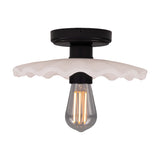 Kapok ceramic ceiling light with a wide, scalloped-edge shade in matt white striped glaze, black lampholder and round ceiling plate, shown with an exposed bulb on a plain white background.