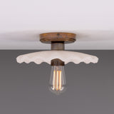 Kapok ceramic ceiling light with a scalloped matt white striped shade, aged brass ceiling plate and lampholder, shown with an exposed bulb against a plain background.