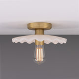 Kapok ceramic ceiling light with a wide scalloped shade in matt white striped glaze, brass lampholder and ceiling plate, exposed bulb, shown against a plain grey background.