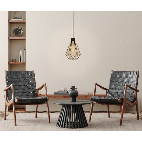 Kirenne fabric pendant light with a faceted black steel frame and warm string-wound shade, hung above a coffee table between two leather armchairs in a living room setting.