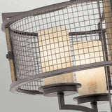 Close-up of the Ahrendale 4 Light Chandelier in Grey, showcasing two cylindrical lamps enveloped in an Anvil Iron mesh with a rustic, industrial finish. The backdrop features a soft gradient of gray tones that enhances its rustic appeal.