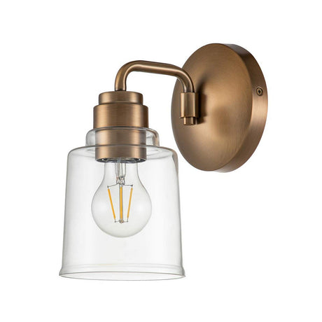 The Aivian 1 Light Wall Light - Weathered Brass boasts a wall-mounted sconce complete with a cylindrical glass shade, highlighted by a vintage-style bulb and industrial design. Its weathered brass metal base enhances its timeless appeal.